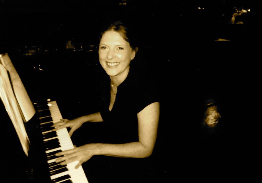 Linda McGann playing music at her piano
